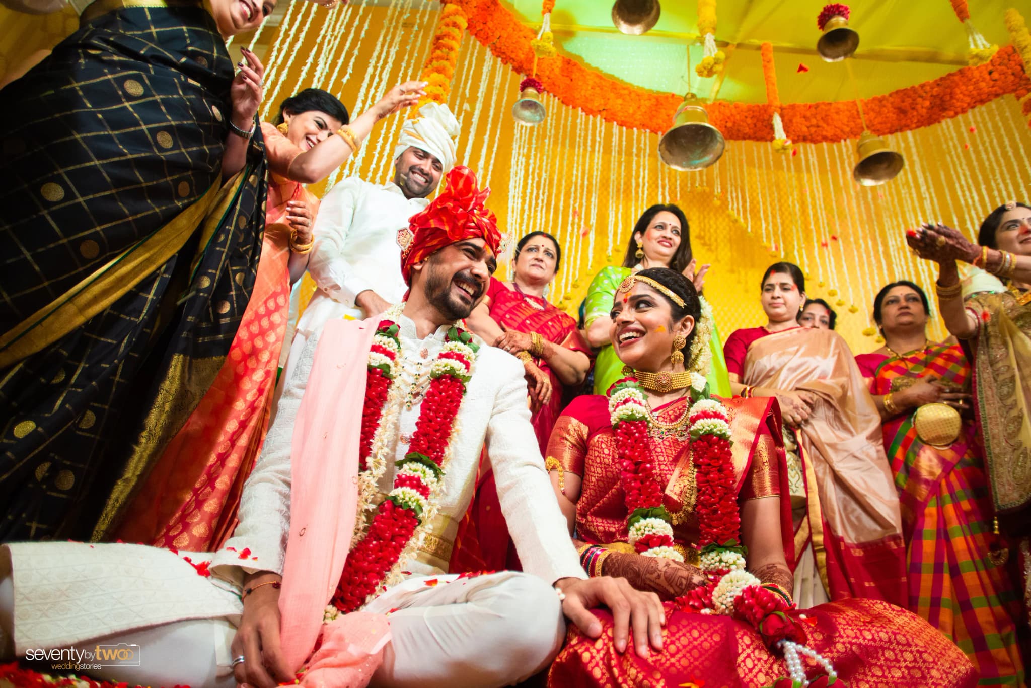 Karan and Madhavi laughing with family during a colourful Goa wedding ritual