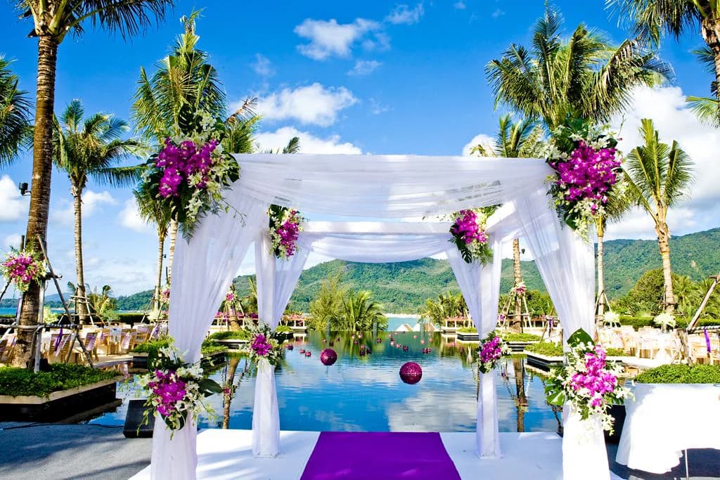 White and purple wedding mandap beside an infinity pool at Andara Phuket