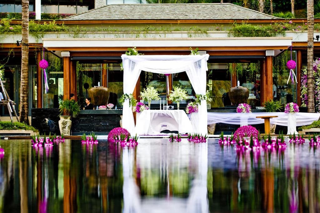 Waterfront wedding canopy reflected in a pool at Andara Resort Phuket