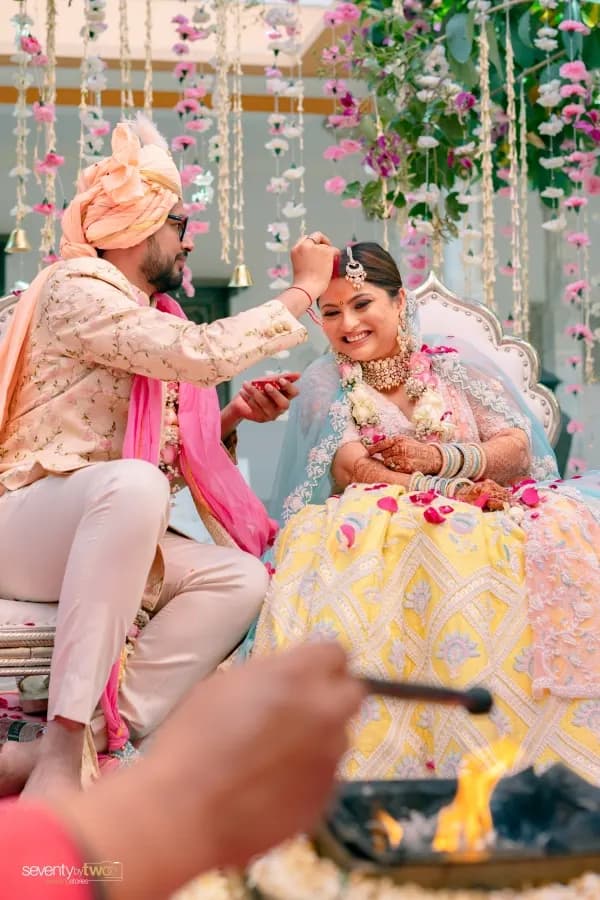 Couple at a ceremony moment under a floral mandap in Udaipur