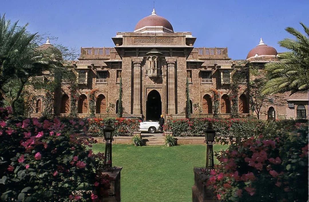 Liveried attendant with silver service and rose detailing at Ajit Bhawan Palace Jodhpur