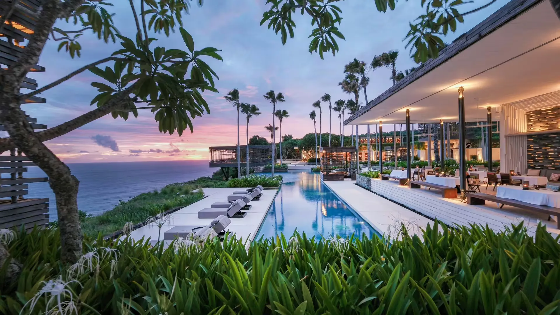 CIRE restaurant poolside terrace at sunset over the cliffs at Alila Villas Uluwatu, Bali