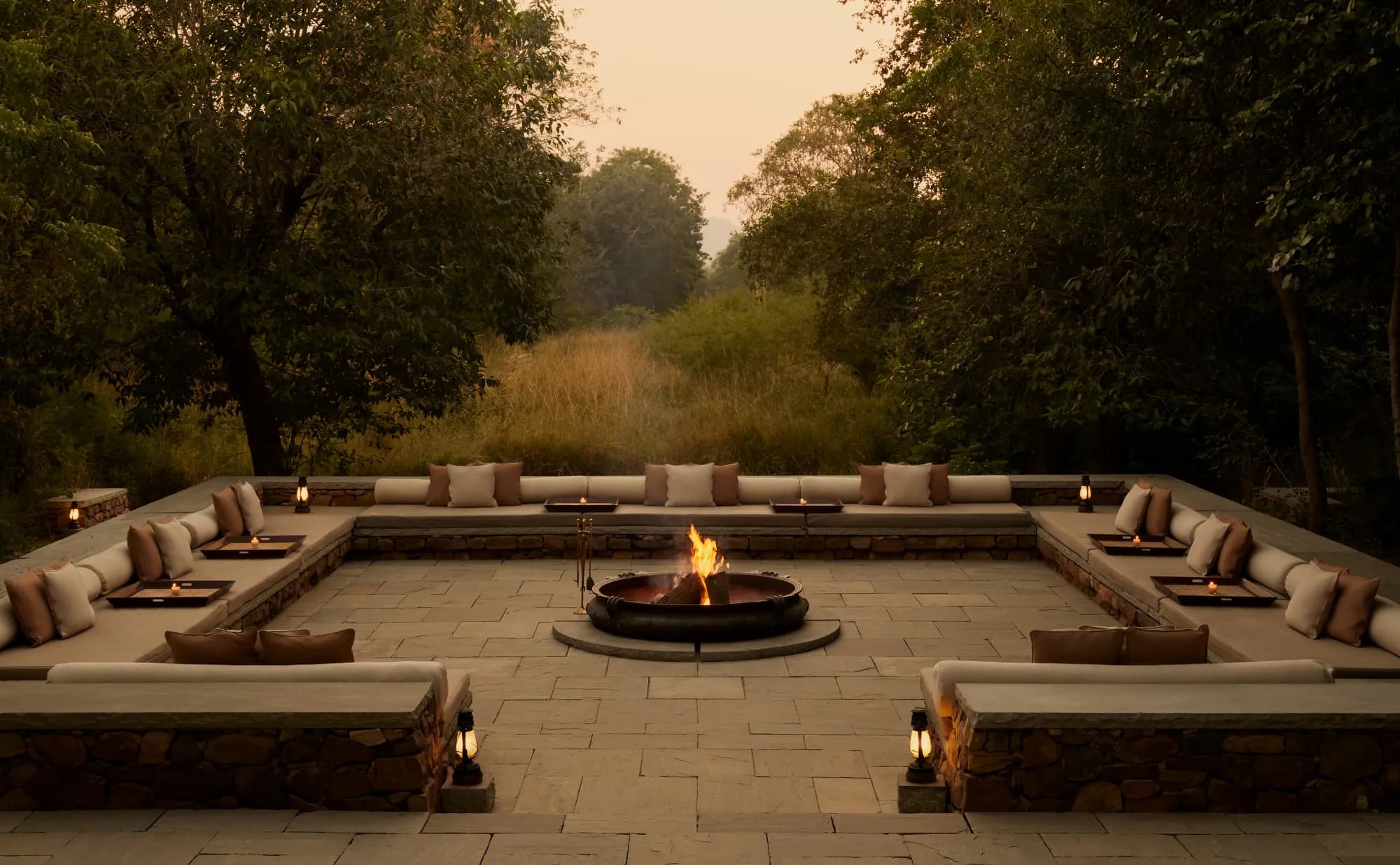 Open-sided lounge tent exterior glowing with warm light at dusk at Aman-i-Khas Ranthambore