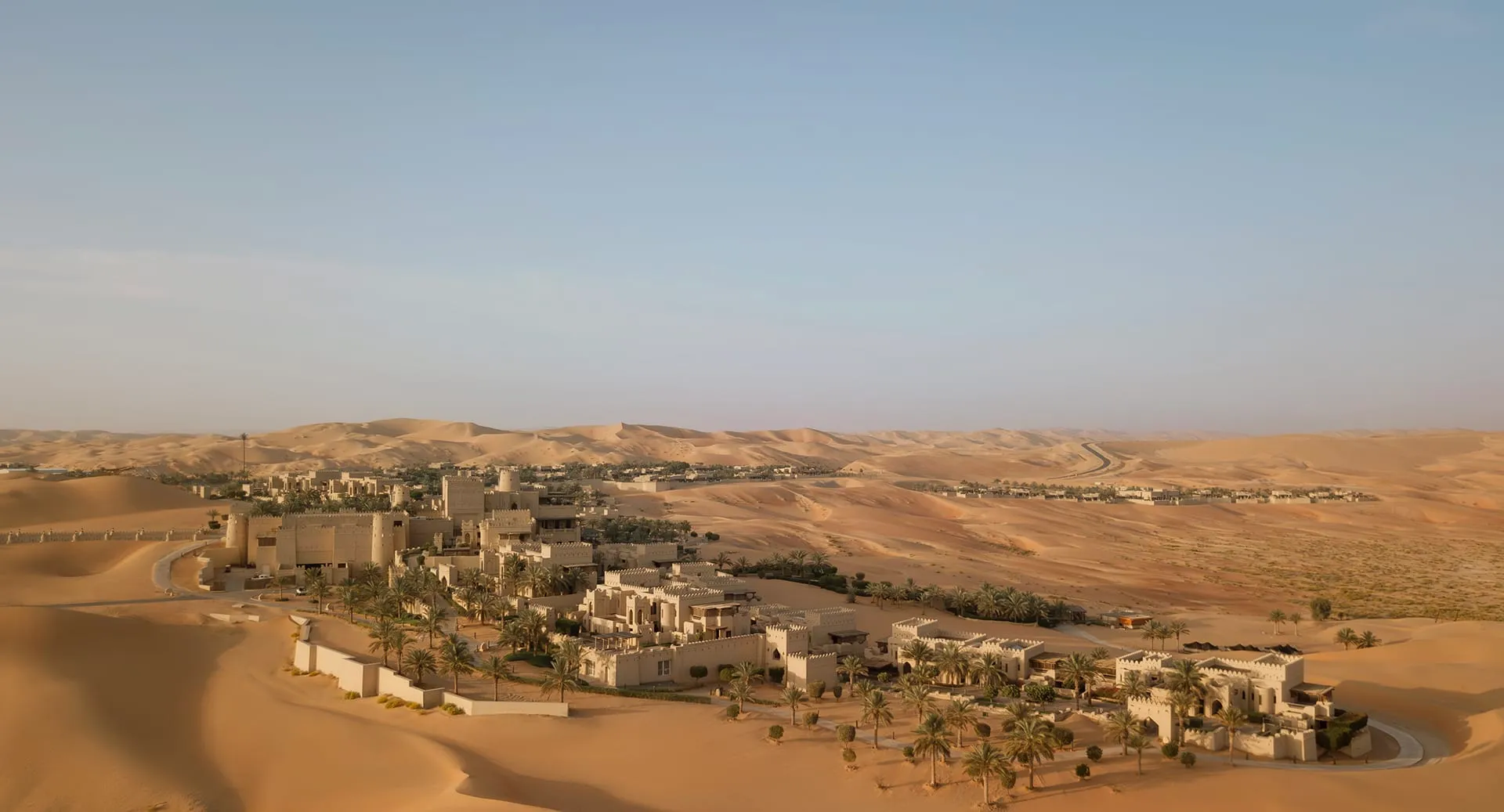 Anantara Qasr Al Sarab fortress-style resort exterior rising from the orange Empty Quarter dunes, Abu Dhabi