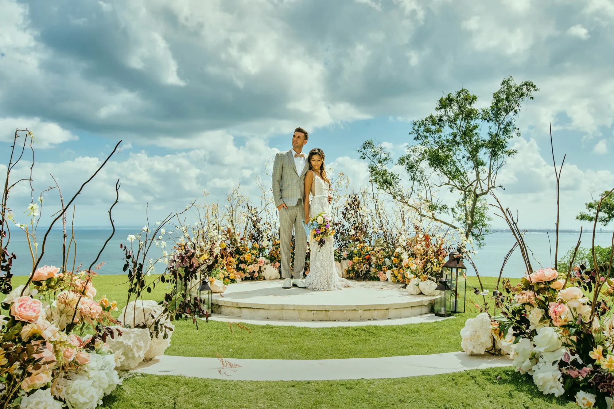Couple on the round SKY ceremony platform with a floral arch on the clifftop above the Indian Ocean at AYANA Estate Bali, Jimbaran
