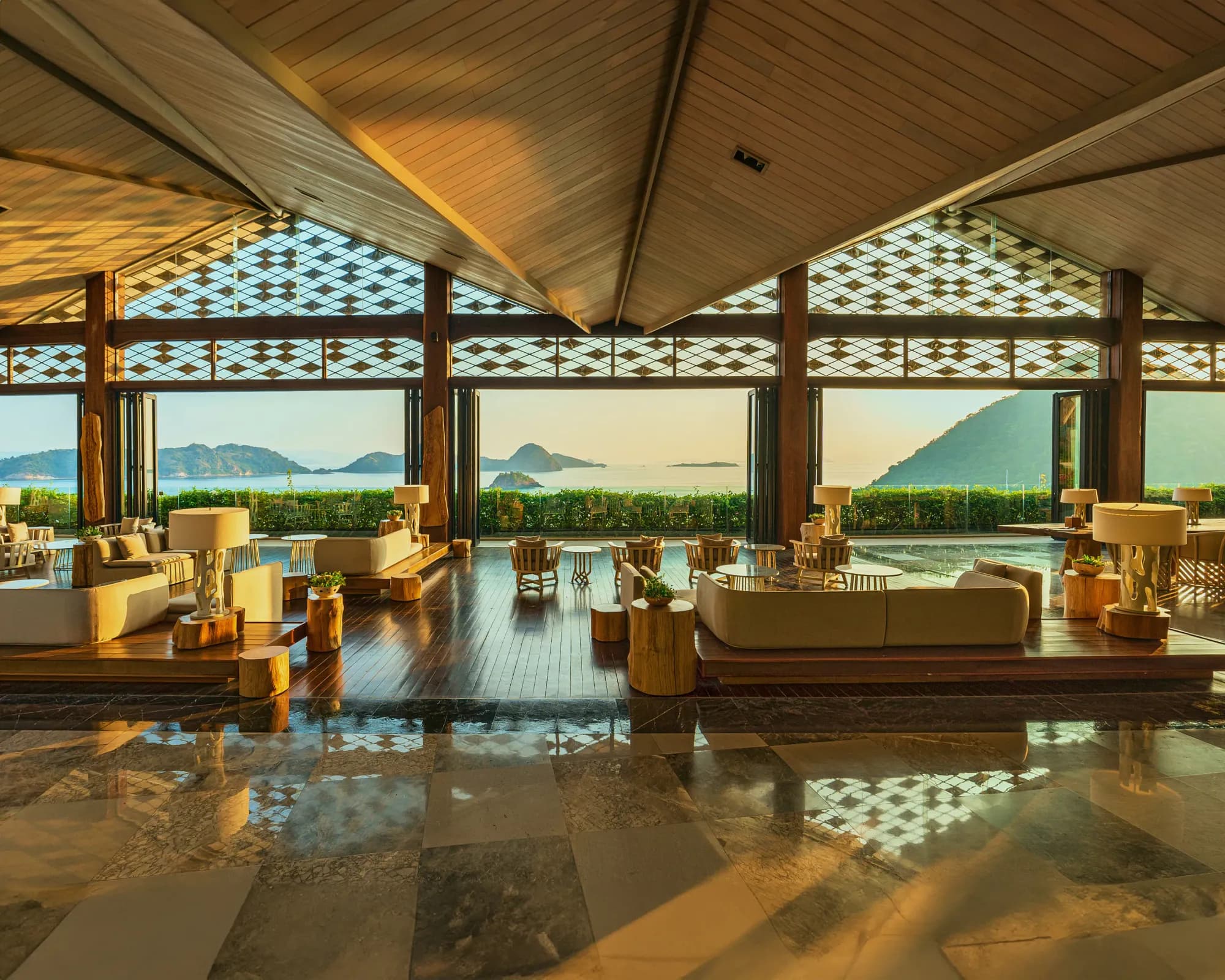 Open-air lobby lounge with sofas and floor-to-ceiling ocean views at AYANA Estate Bali, Jimbaran