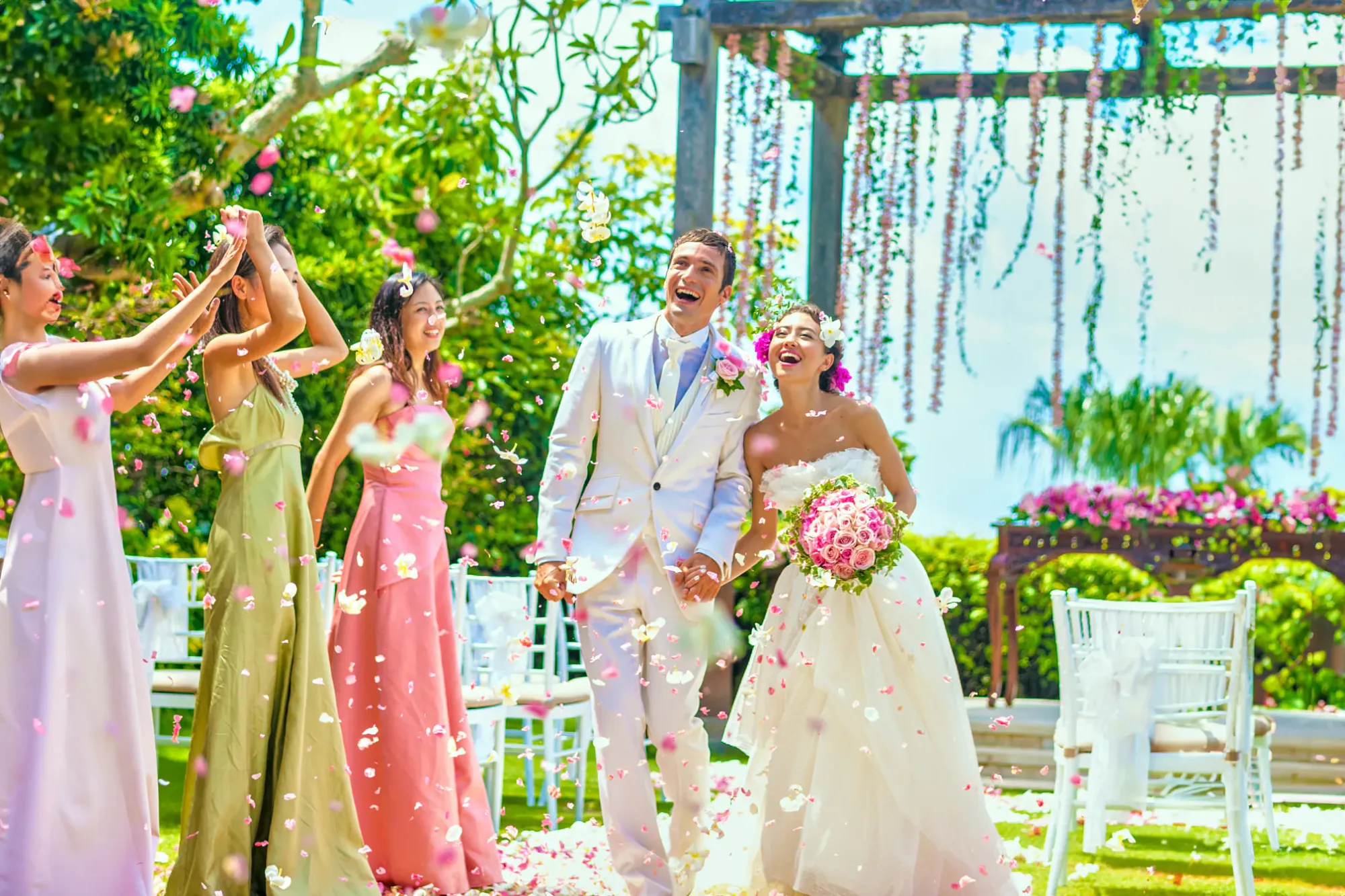 Couple and bridesmaids at a garden celebration with hanging florals at AYANA Estate Bali, Jimbaran