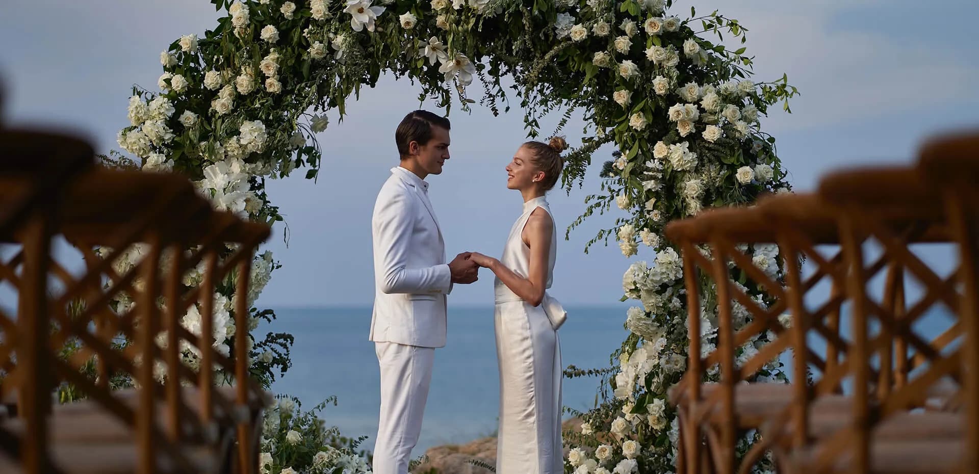 Aerial of Cape Fahn dedicated Wedding Terrace deck with chairs and a floral arch on the headland above the Gulf of Thailand