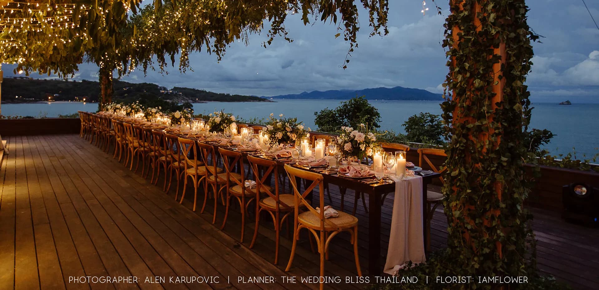 Cape Fahn long candle-lit wedding dinner table on the open-air terrace deck overlooking the Gulf of Thailand at dusk