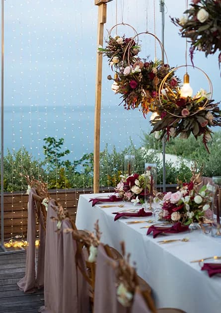Cape Fahn couple at a white floral arch on the black headland deck above the Gulf of Thailand, Koh Samui private island