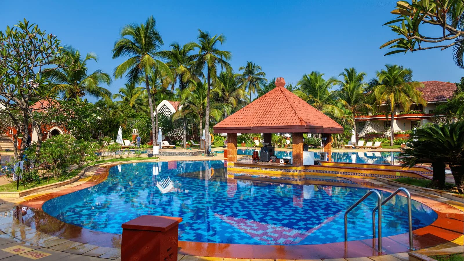 Outdoor swimming pool and swim-up bar at Caravela Beach Resort Goa