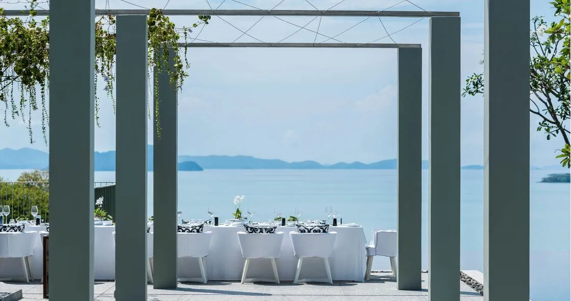 La Sirena poolside terrace at COMO Point Yamu Phuket set with round tables overlooking the ocean for a reception