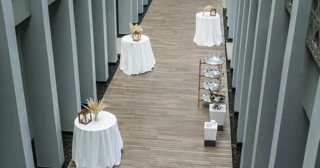 Wooden walkway lined with tables and chairs for a dinner over Phang Nga Bay at COMO Point Yamu Phuket