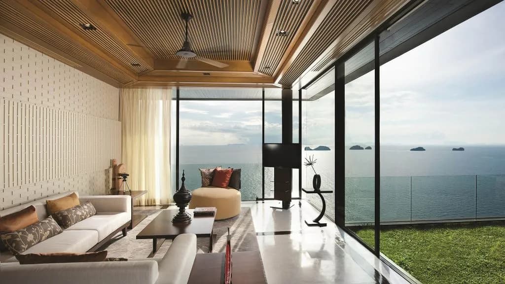 Two-bedroom panoramic pool villa living area opening to an ocean-view deck at Conrad Koh Samui