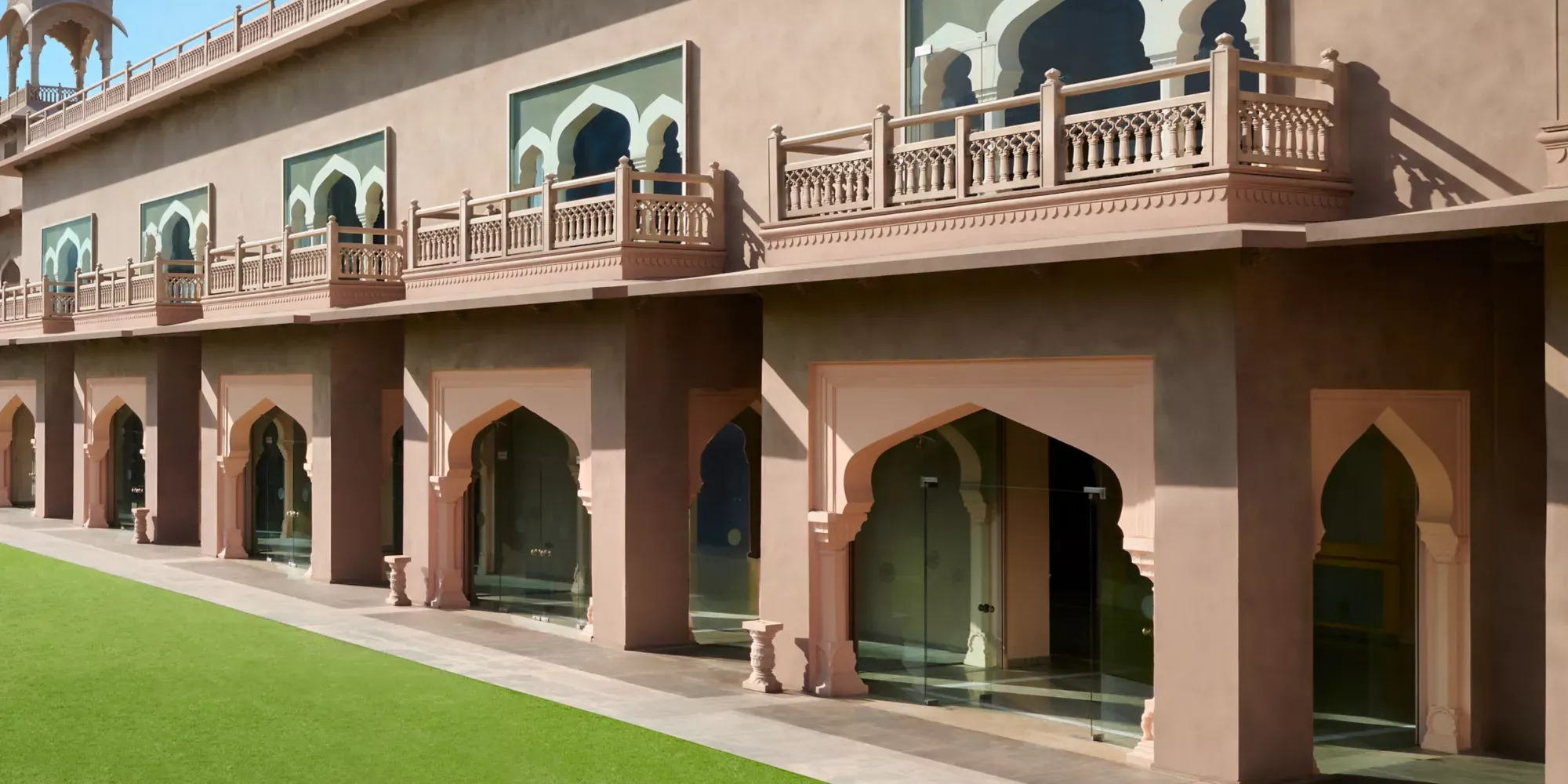 Couple-portrait setting with jharokha balconies and Pink-City heritage architecture at Fairmont Jaipur