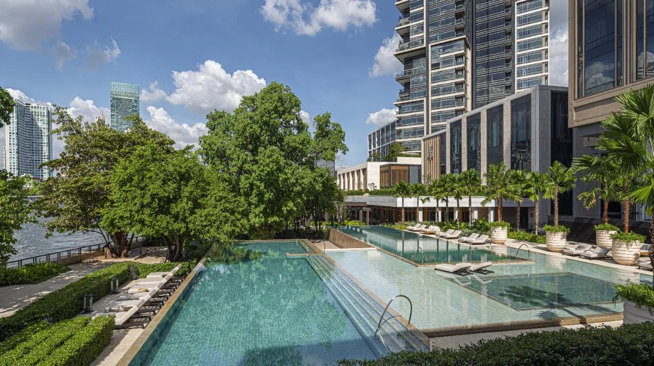 Riverside outdoor swimming pool with palms overlooking the Chao Phraya River at Four Seasons Hotel Bangkok