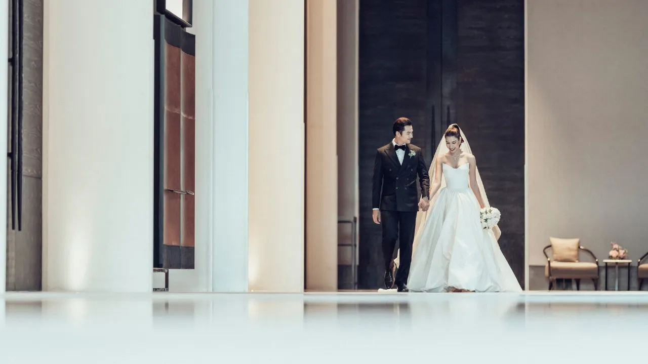 Bride and groom walking through the grand ballroom pre-function foyer at Four Seasons Hotel Bangkok