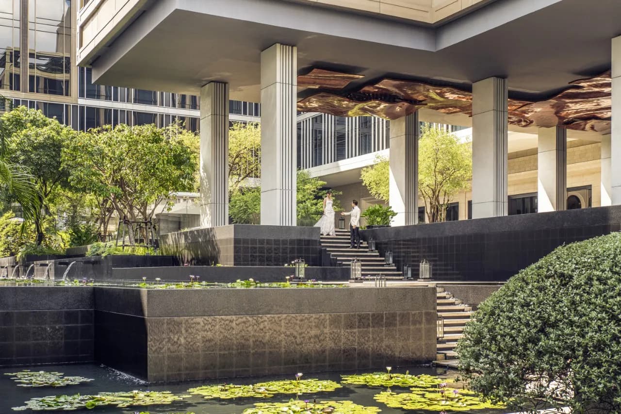 Bride and groom in the landscaped water-garden courtyard at Four Seasons Hotel Bangkok at Chao Phraya River