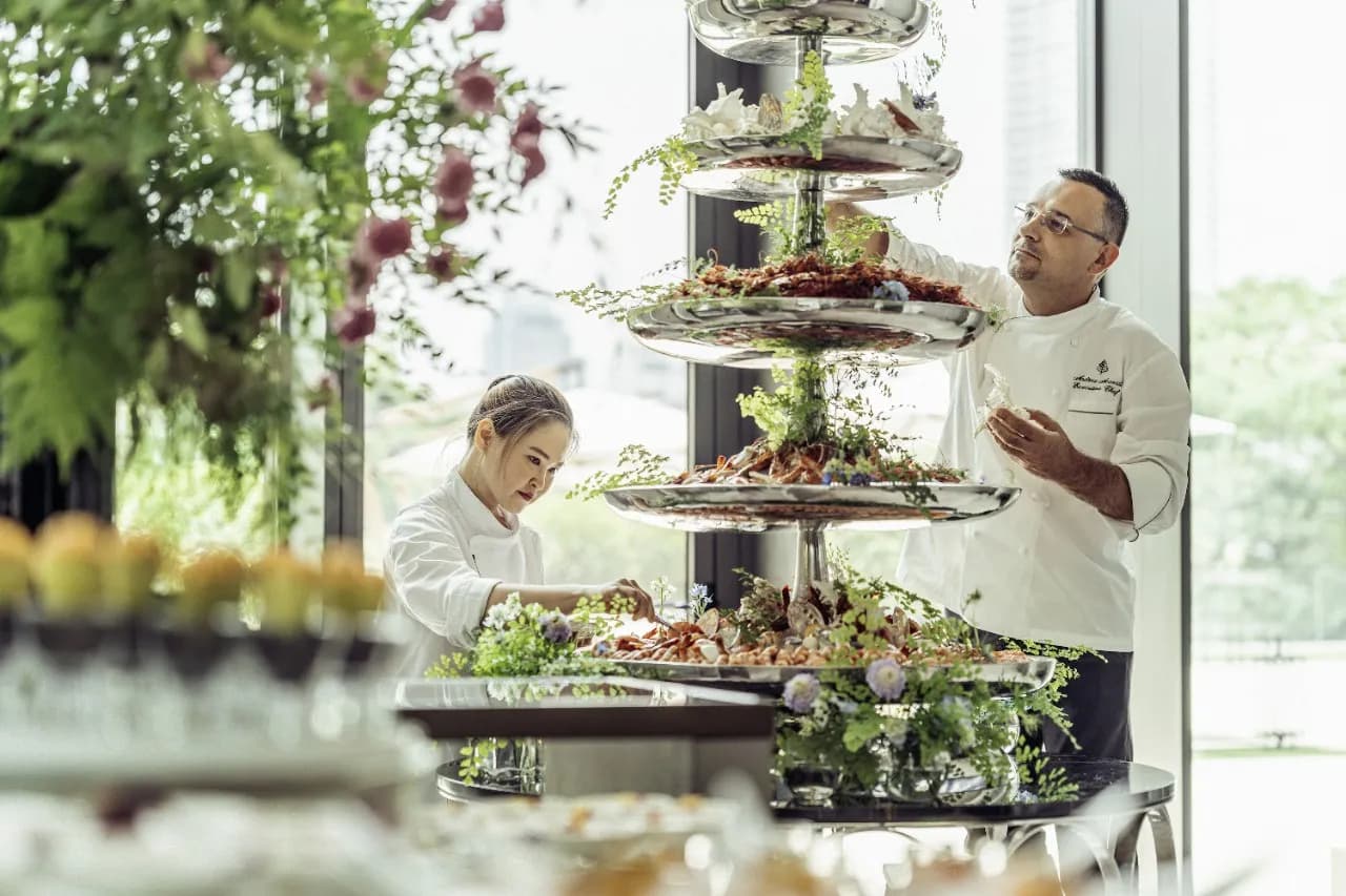 Four Seasons chefs styling a tiered seafood tower beside the river at Four Seasons Hotel Bangkok