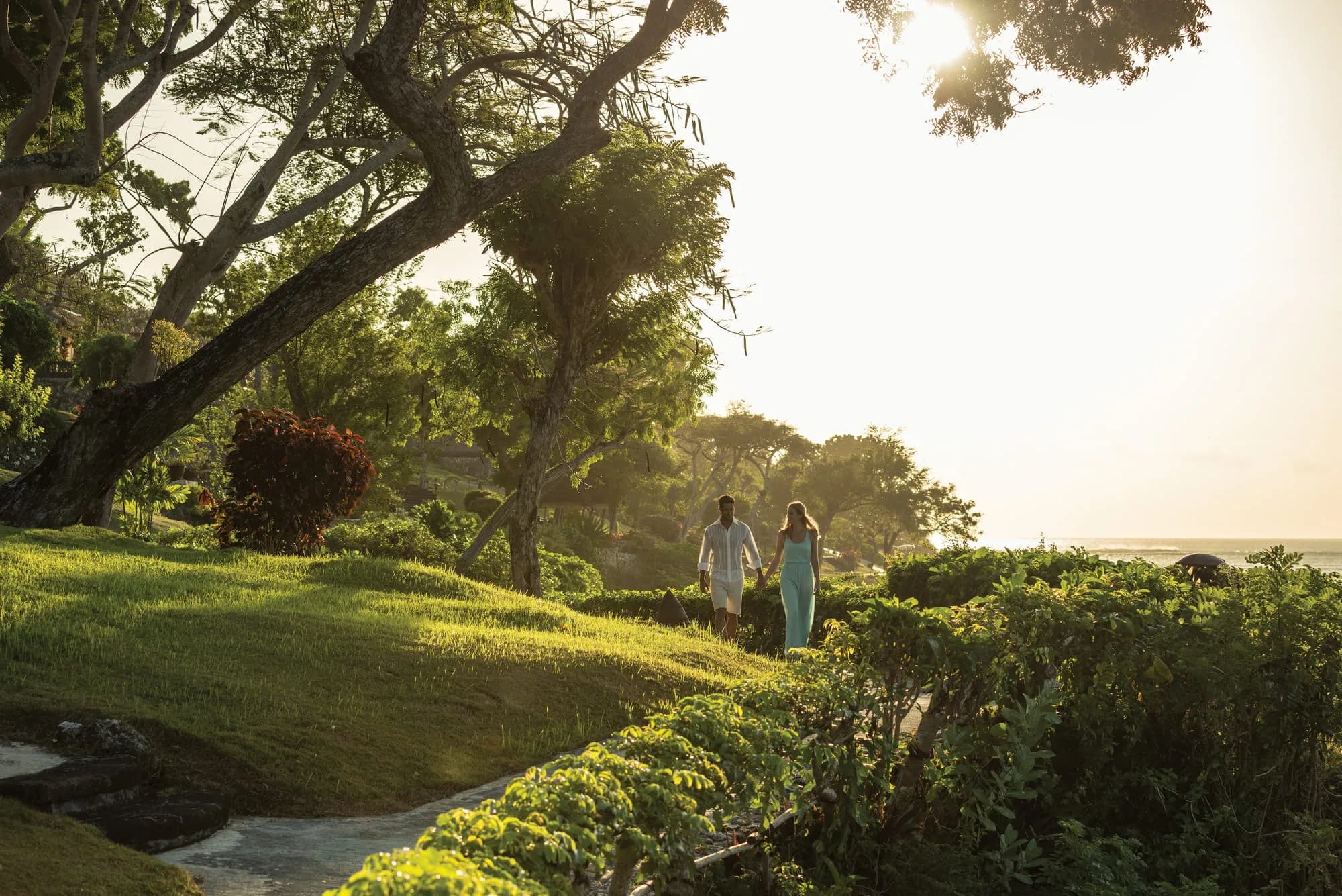 Four Seasons Resort Bali at Jimbaran Bay clifftop infinity pool deck overlooking the sea and sunset at Jimbaran Bay