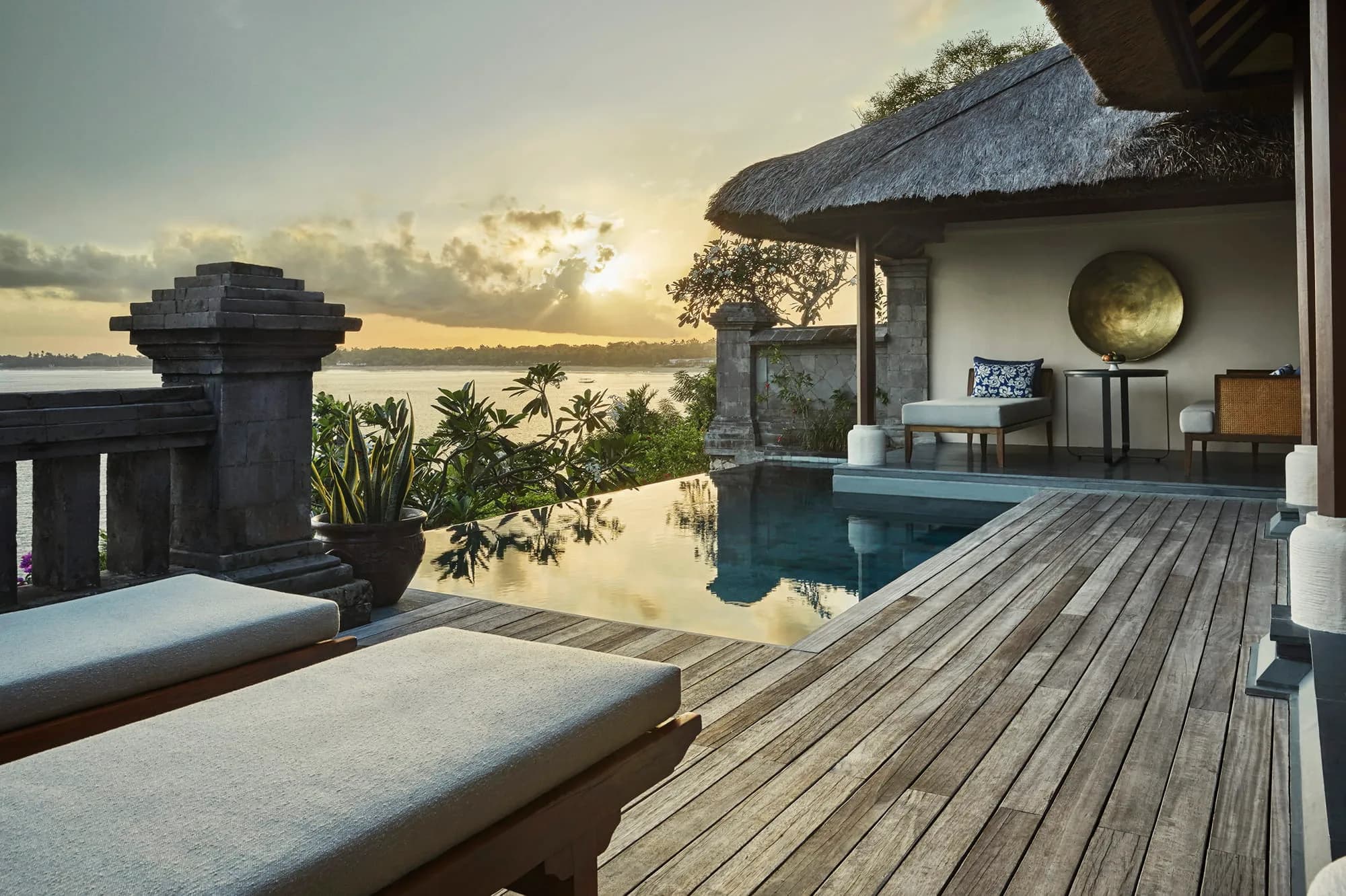 Four Seasons Resort Bali at Jimbaran Bay private cove and Jimbaran Bay coastline at golden-hour sunset on Bali's west coast