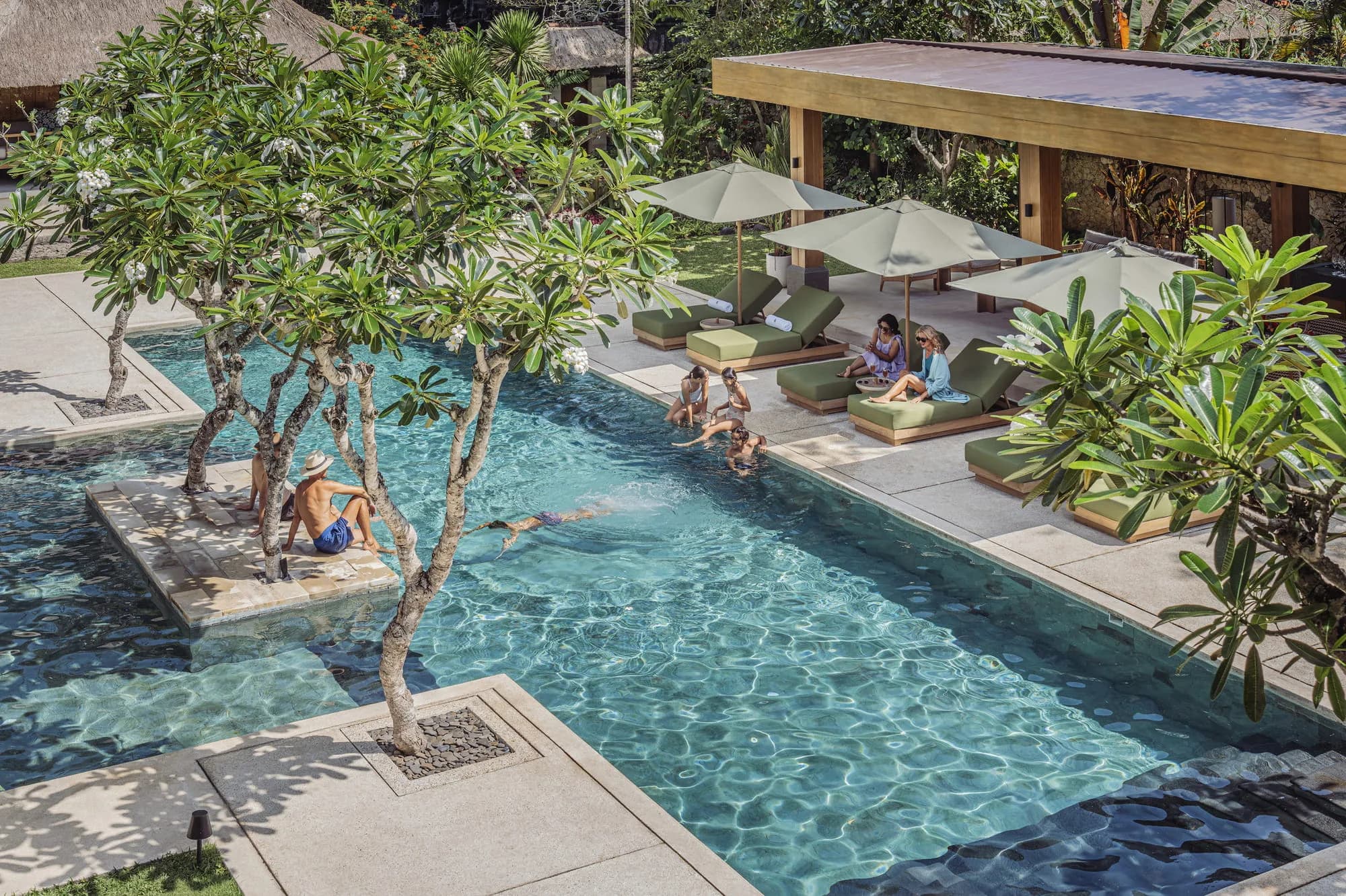 Four Seasons Resort Bali at Jimbaran Bay private cove and the Bali sunset coast glowing gold at golden hour, Jimbaran Bay