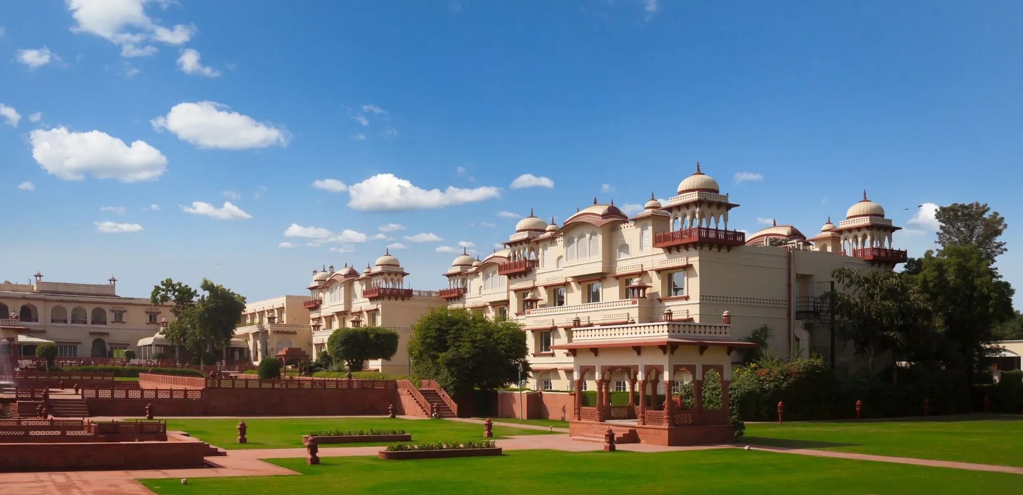 Jai Mahal Palace Jaipur Indo-Saracenic facade above landscaped 18-acre Mughal gardens
