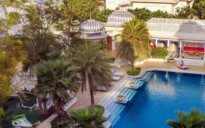 Marble courtyard and swimming pool with the Jharokha poolside bar at The Leela Palace Jaipur