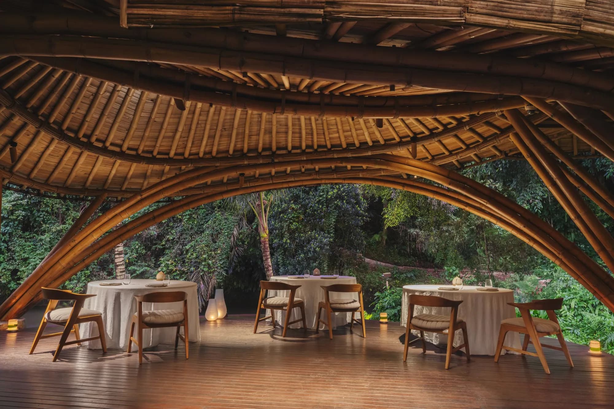 Kubu riverside dining deck beside the Ayung River at Mandapa Ubud Bali, set for an evening function