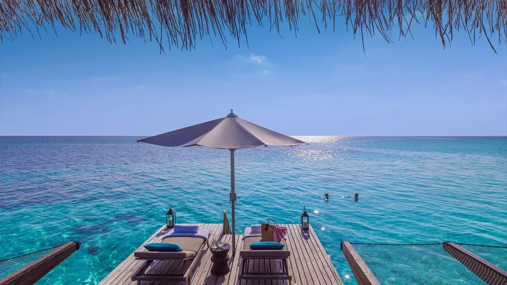 One&Only Reethi Rah water villa outdoor deck and sun loungers over the lagoon, Maldives