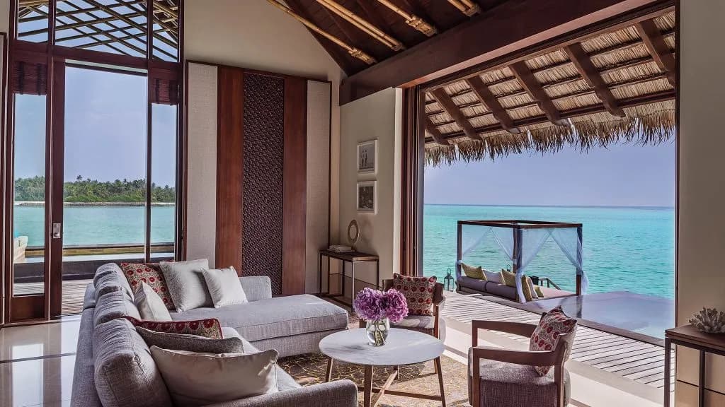 One&Only Reethi Rah grand water villa living room interior opening to the lagoon, Maldives