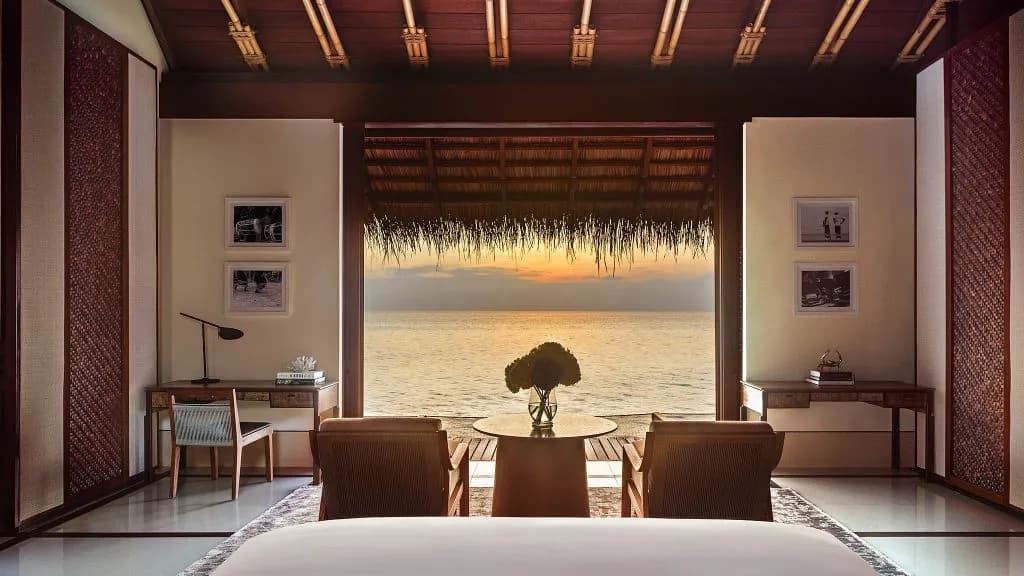 One&Only Reethi Rah water villa view from bed across the turquoise lagoon at sunrise, Maldives
