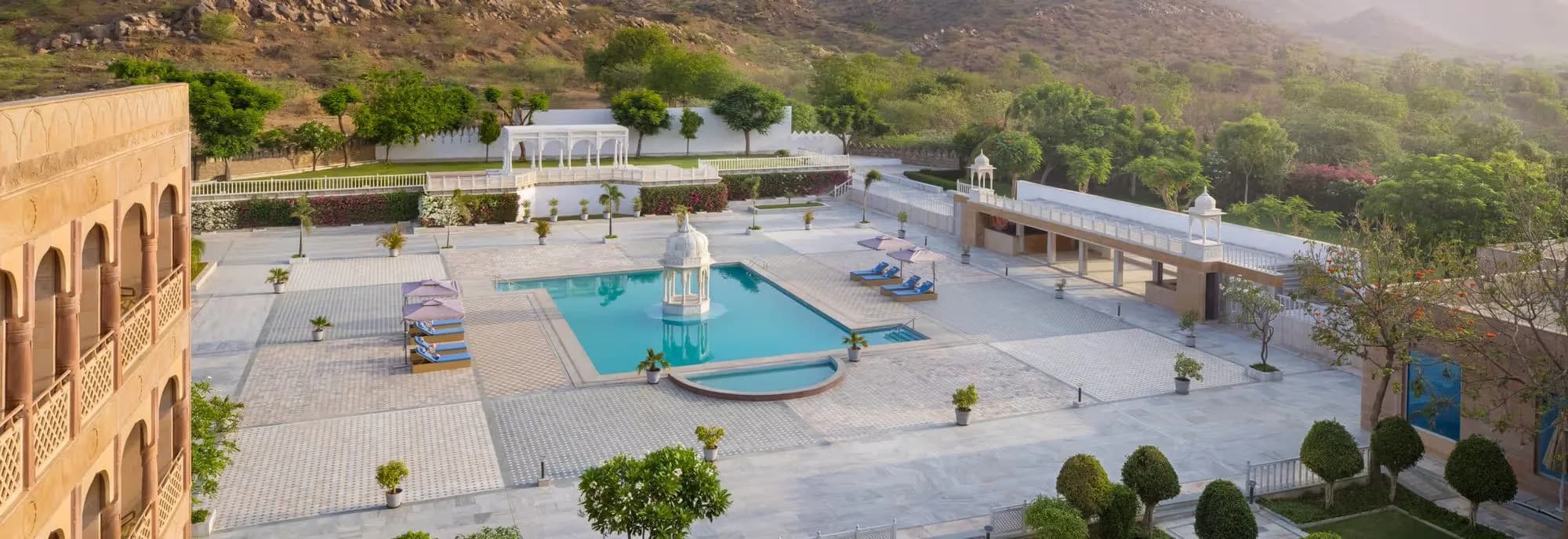 Sweeping poolside with central chhatri pavilion and Aravalli backdrop at Pratap Mahal Ajmer IHCL SeleQtions
