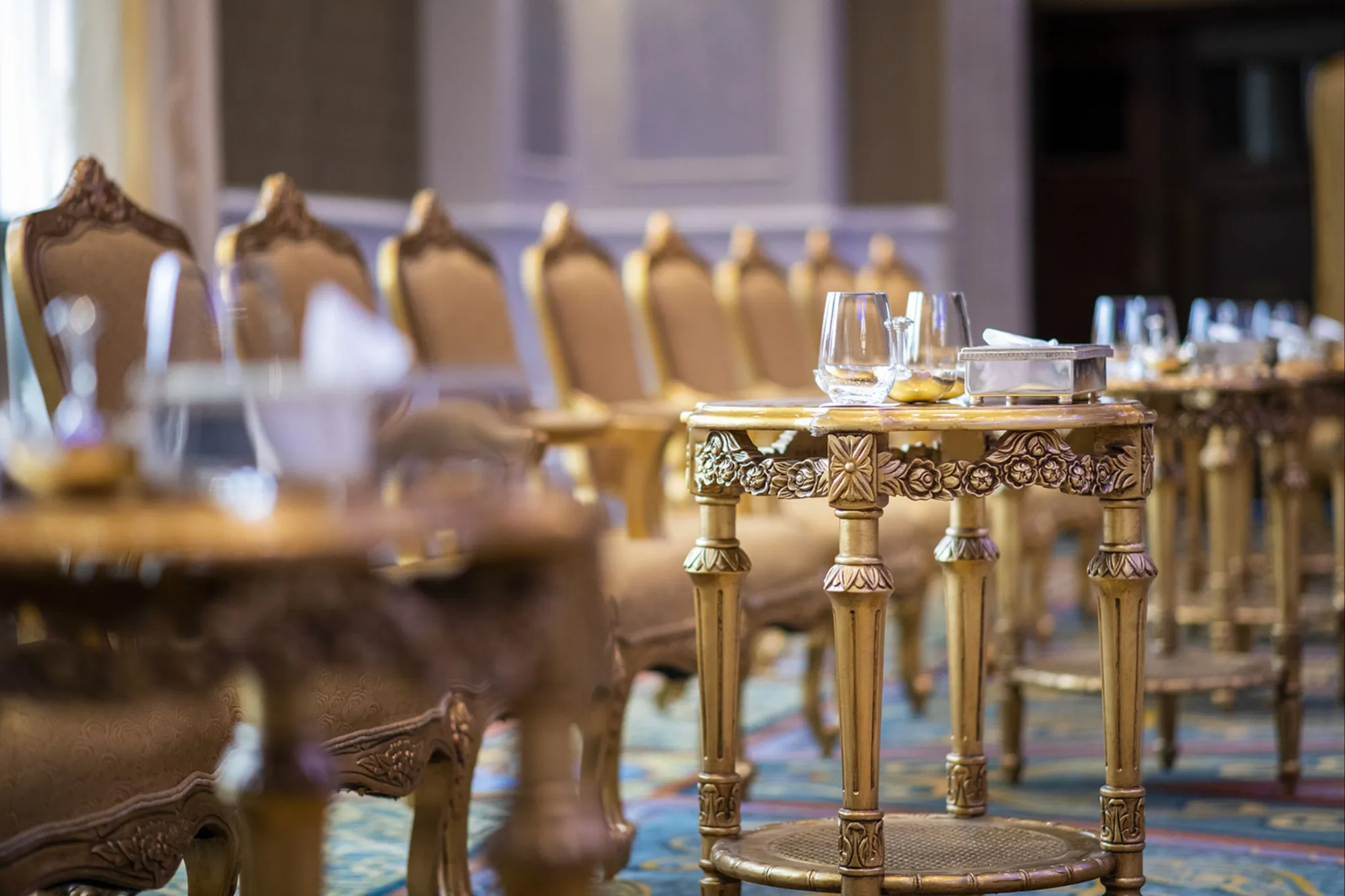 Gilded carved chairs and table set for a banquet inside the ballroom at The Ritz-Carlton Abu Dhabi Grand Canal