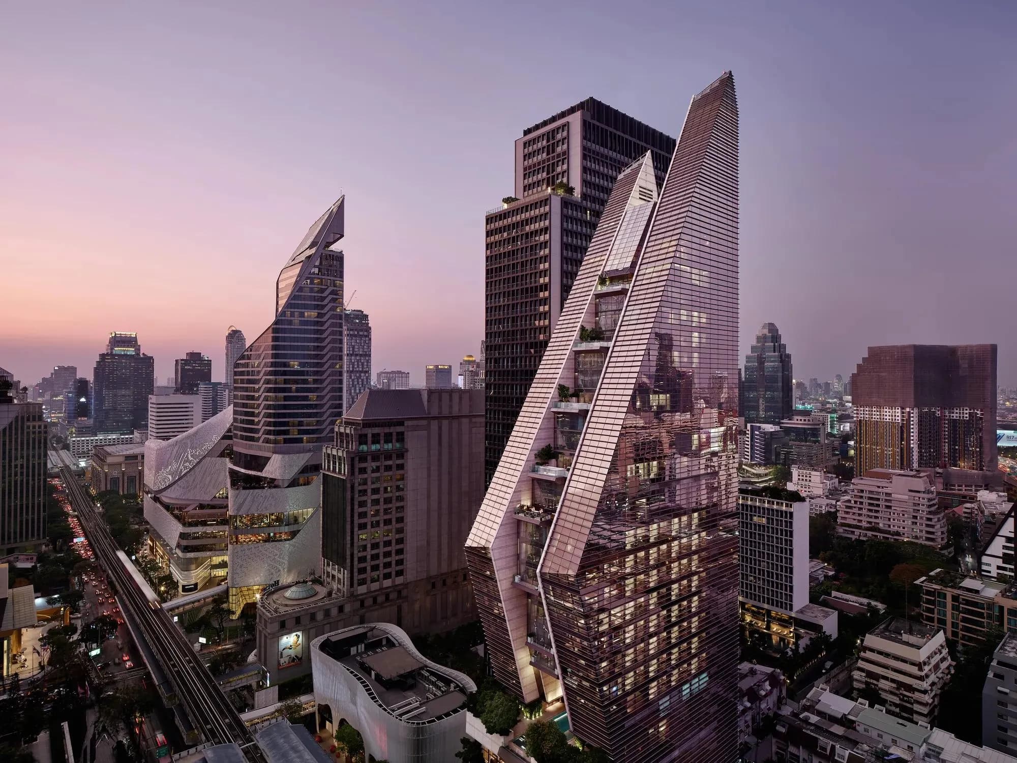 Rosewood Bangkok contemporary glass zen-tower hotel facade with its signature angled volumes over Ploenchit Road, Bangkok