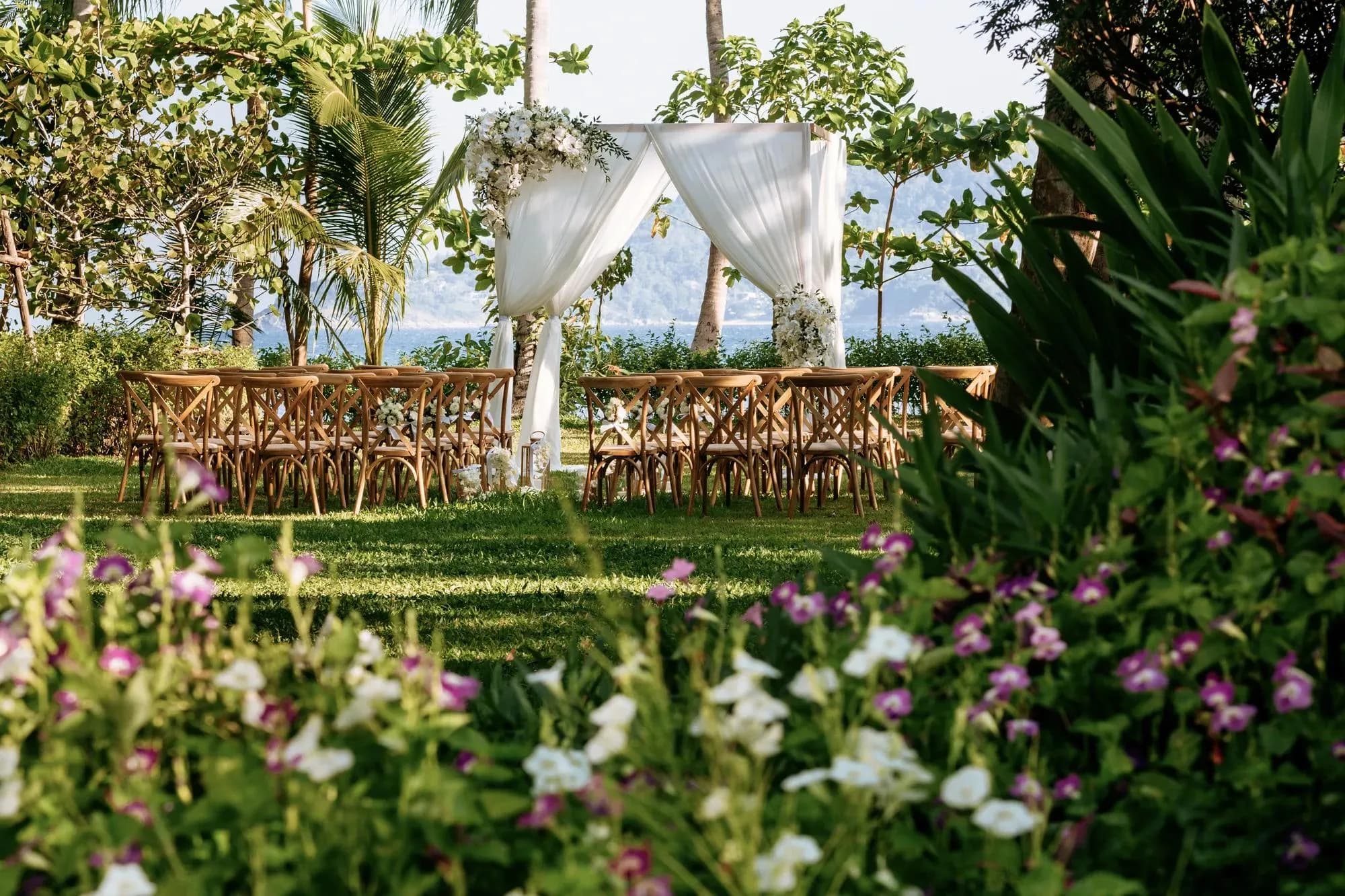 Wedding ceremony setup on the garden lawn above the sea at Rosewood Phuket, Emerald Bay Phuket