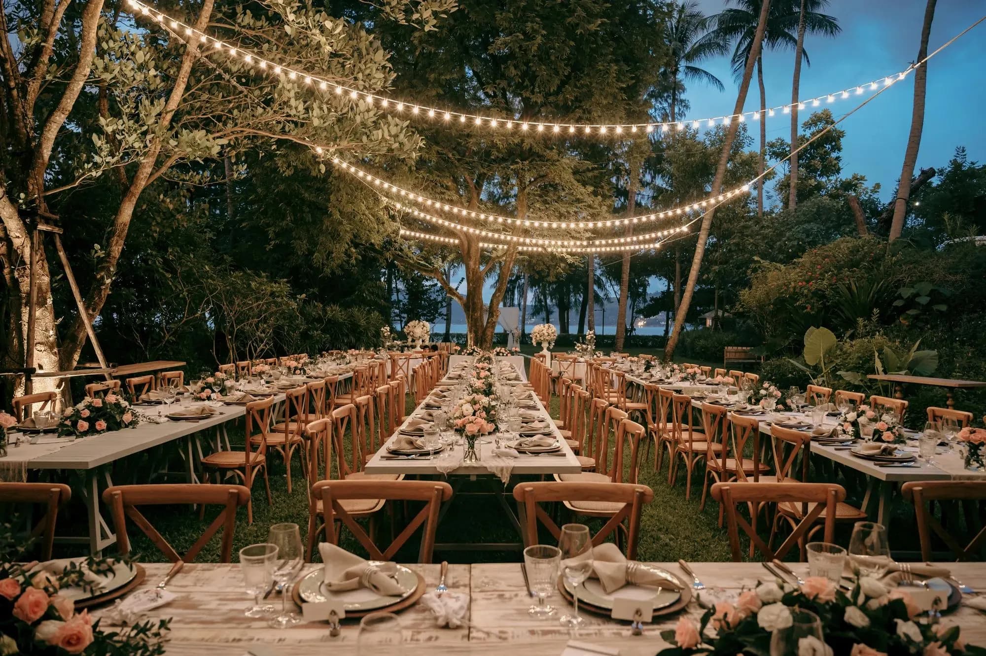 Evening outdoor wedding dinner setup under the stars at Rosewood Phuket, Emerald Bay Phuket