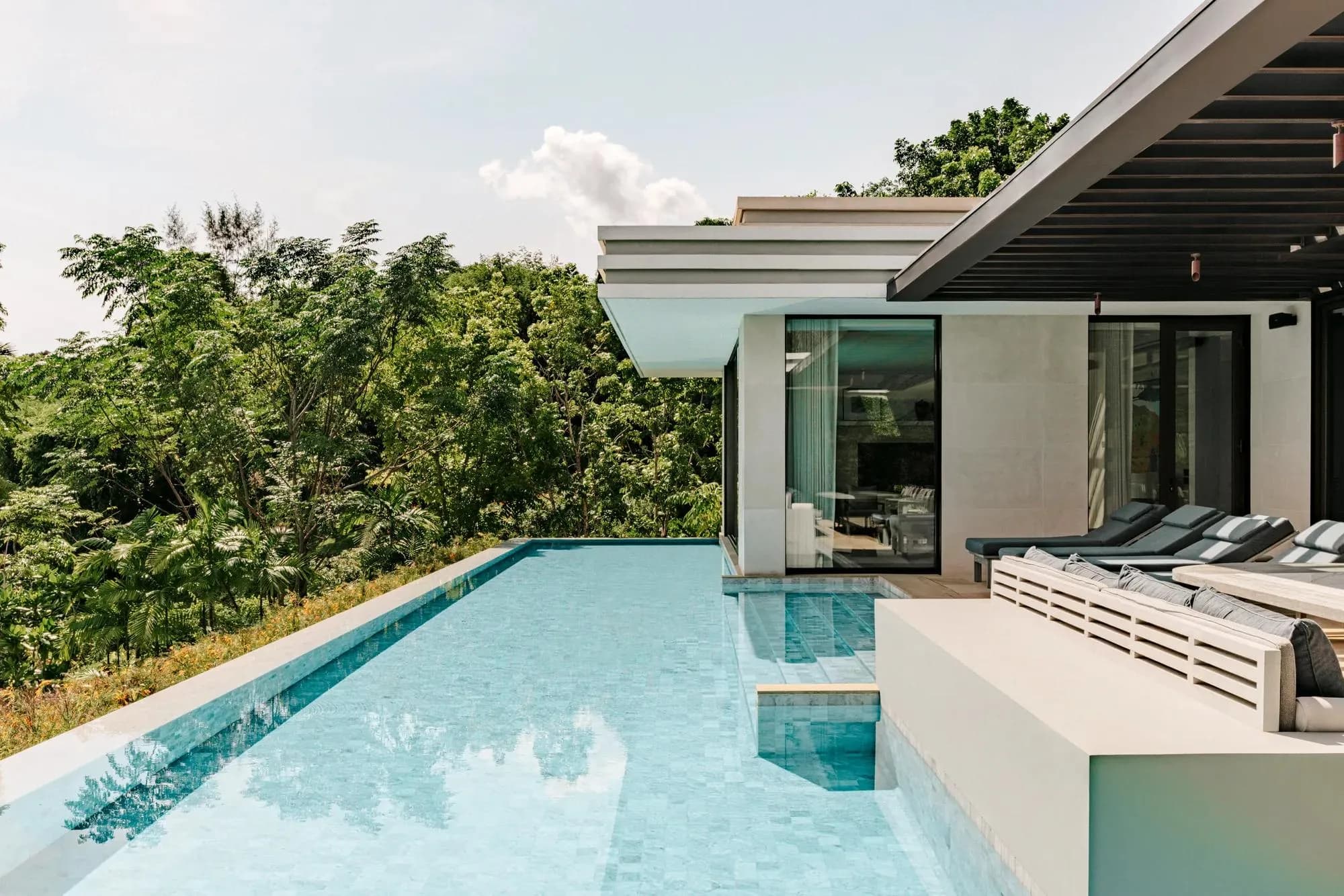 Private pool villa with cascading pools at golden hour over Emerald Bay, Rosewood Phuket