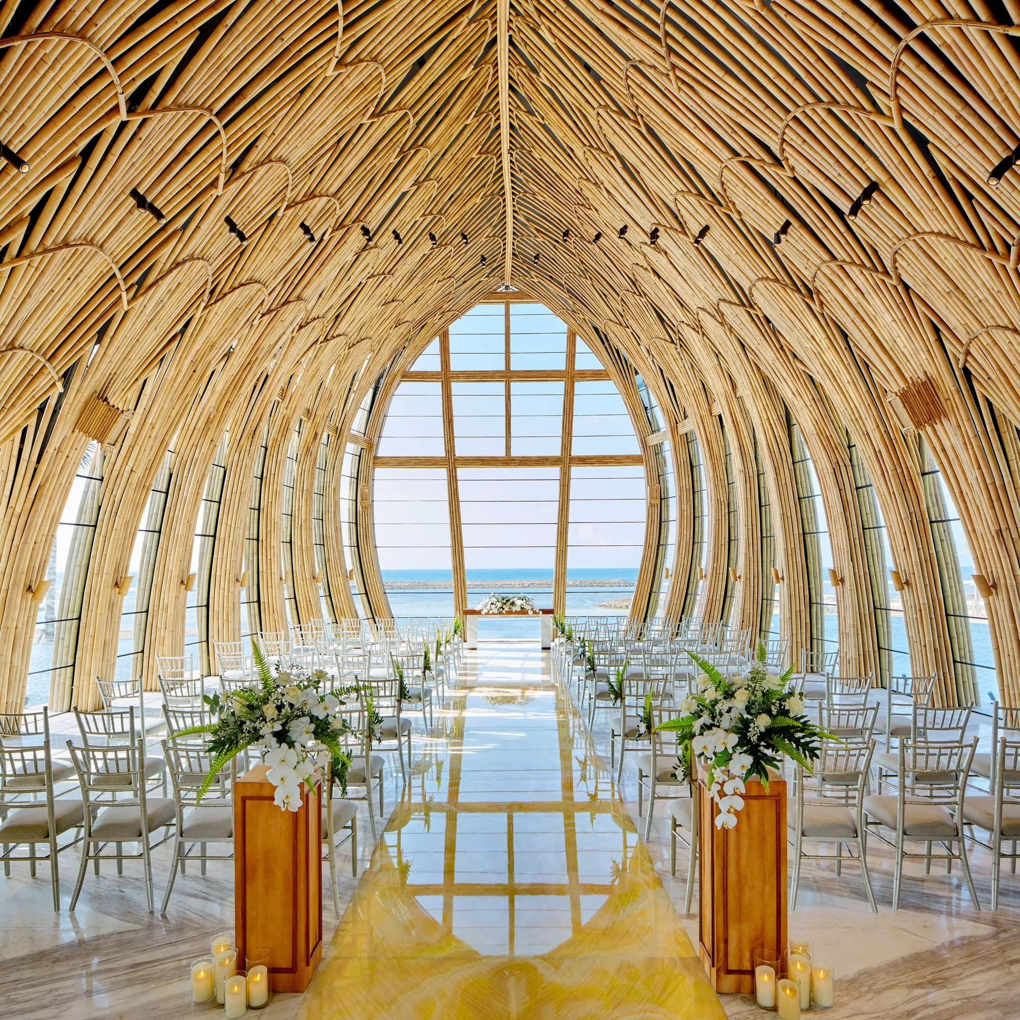 Interior of the glass Ocean Front Apurva Chapel with soaring bamboo and ocean views at The Apurva Kempinski Bali, Nusa Dua