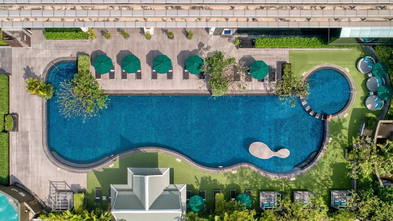 Outdoor swimming pool deck with Bangkok city skyline at The Athenee Hotel Bangkok
