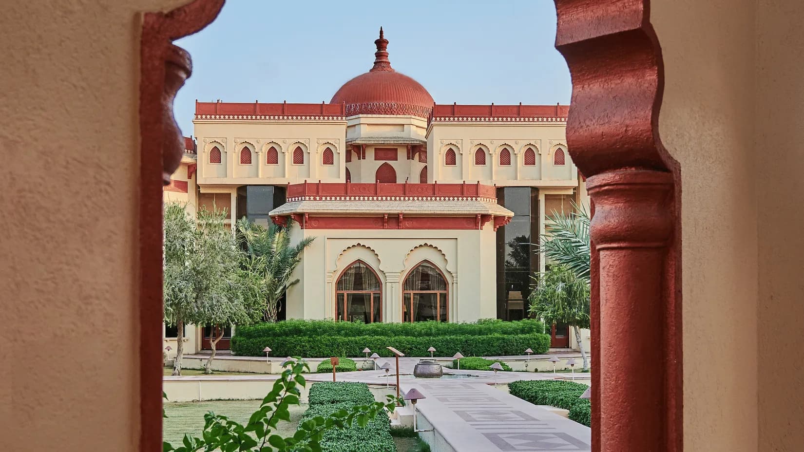 Green lawns and sandstone palace domes of The Ummed Jodhpur at the edge of the Thar desert