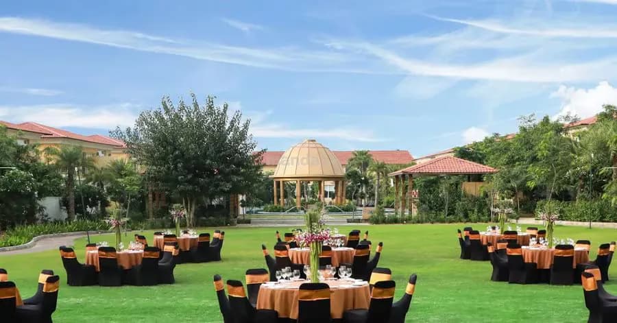 Lawn function setup with round tables and a poolside gazebo at The Westin Pushkar Resort & Spa, Pushkar