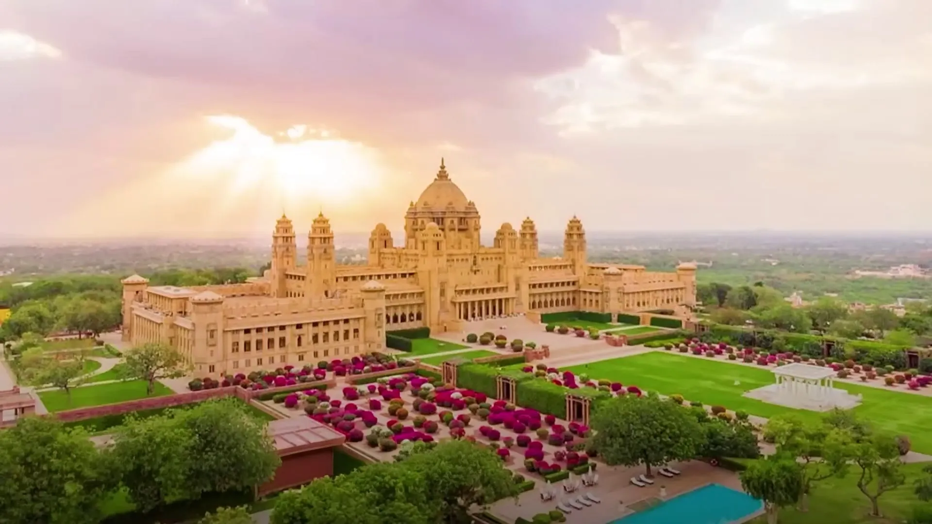 Umaid Bhawan Palace Jodhpur golden sandstone Art-Deco facade and central dome at dusk above the Blue City