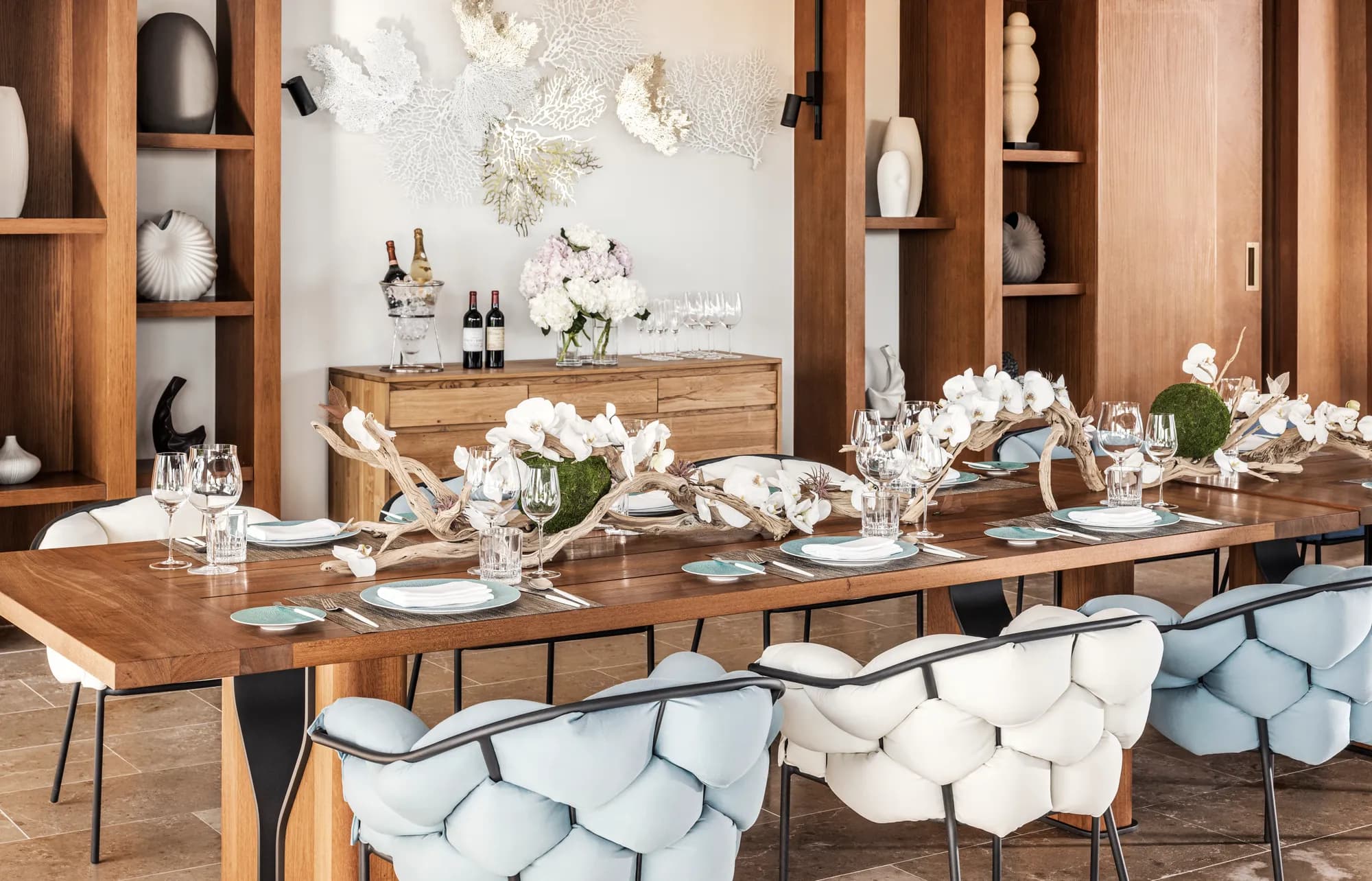 Private-dining tablescape with white orchids, driftwood and coral decor at Waldorf Astoria Maldives Ithaafushi