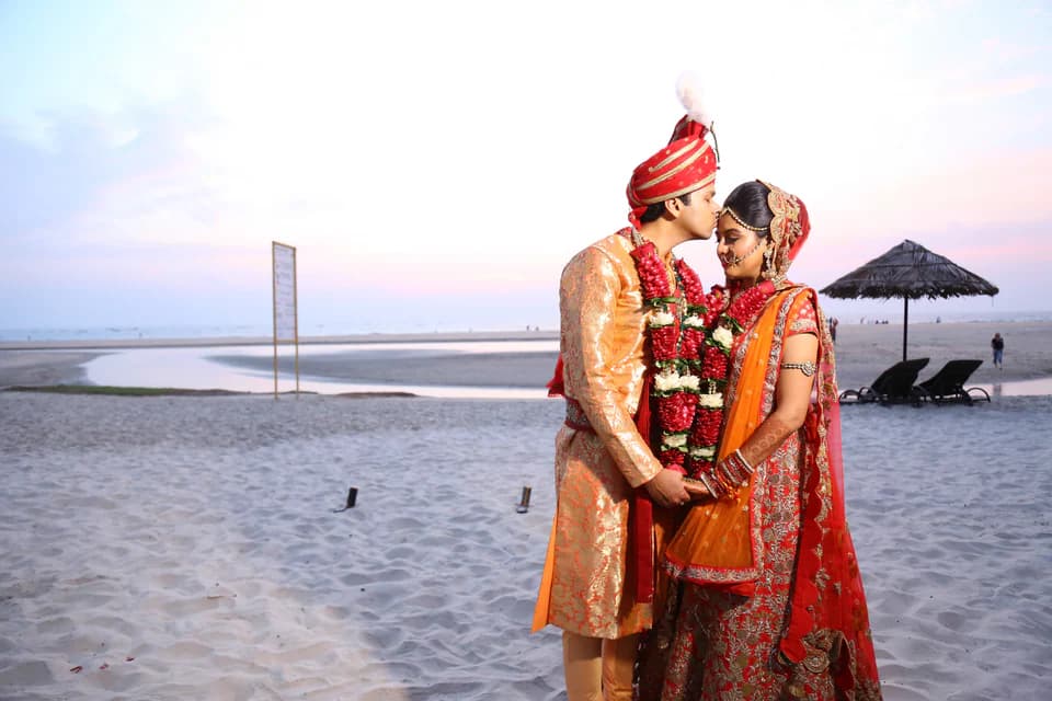 Raghav and Radhika standing together on a quiet beach after their wedding ceremony