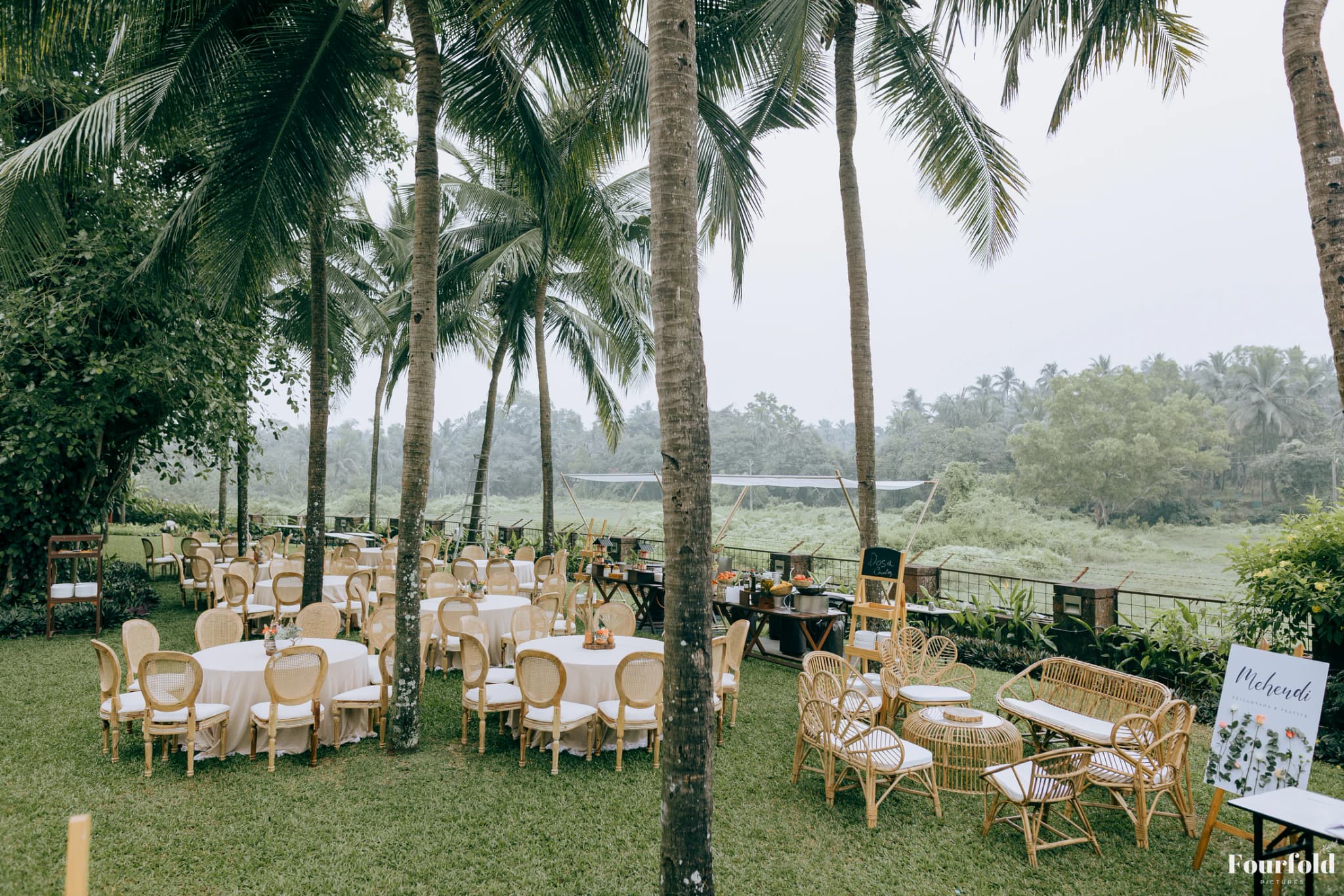 Lakeside wedding welcome seating arranged beneath coconut palms