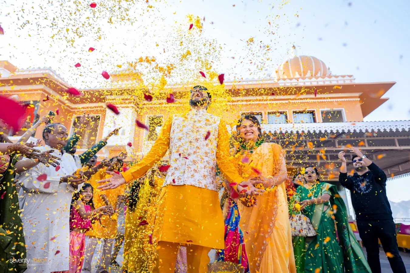 Couple at a haldi celebration with a palace backdrop in Udaipur