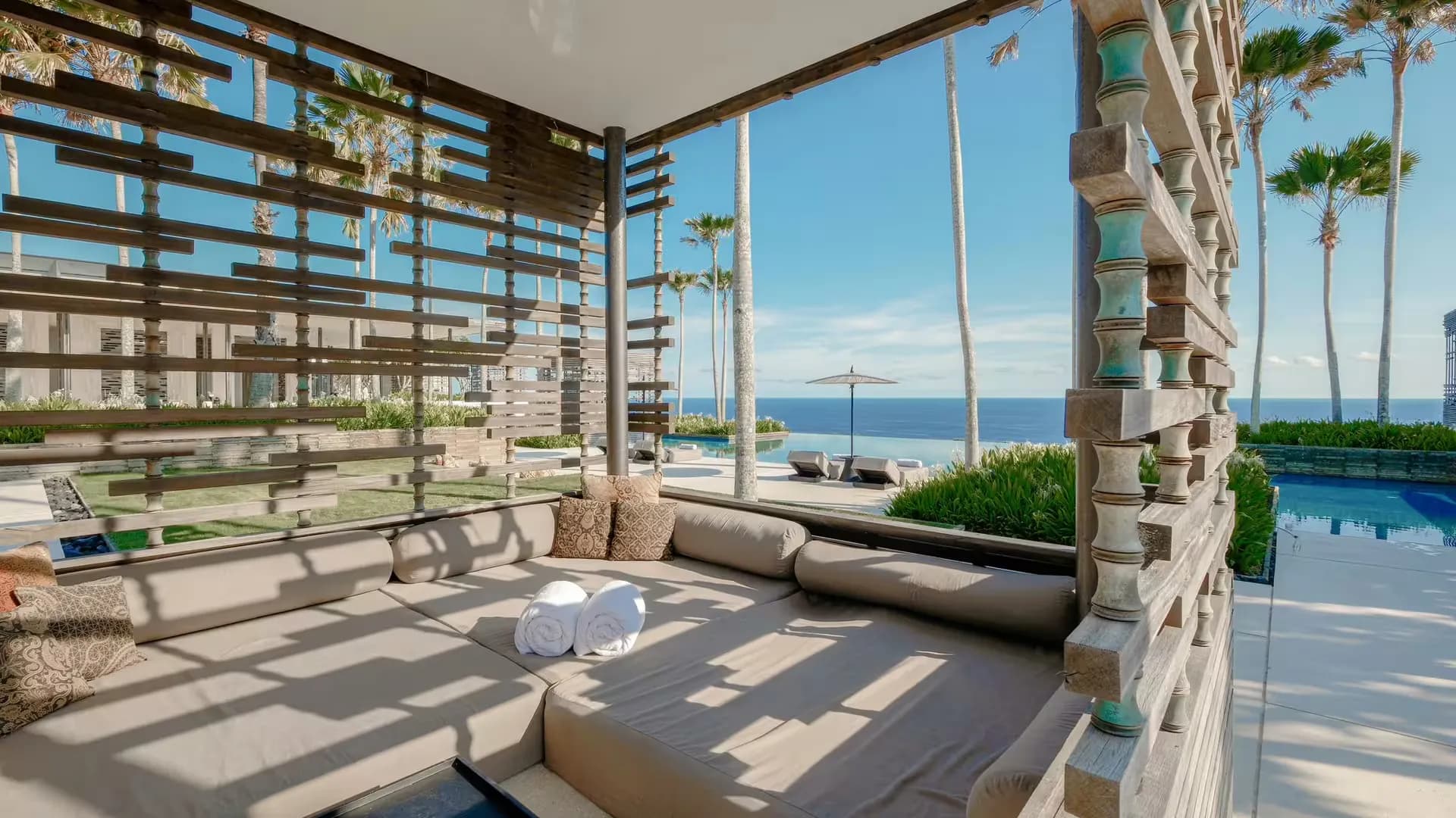 Cliff-edge Main Pool and cabana view set for an evening dinner at Alila Villas Uluwatu, Bali