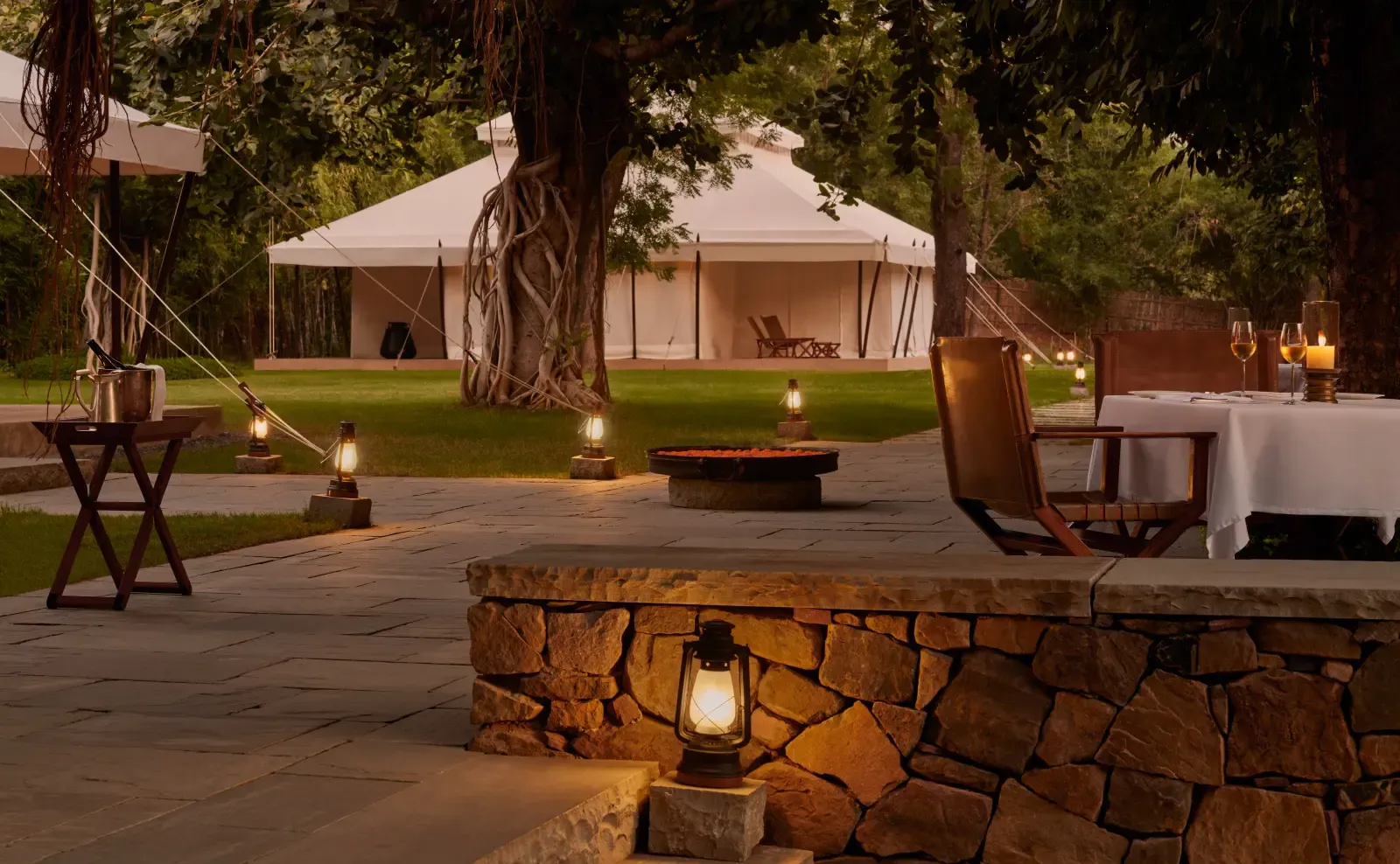 Wooden walkway leading through trees into the Aman-i-Khas tented camp at golden hour, Ranthambore
