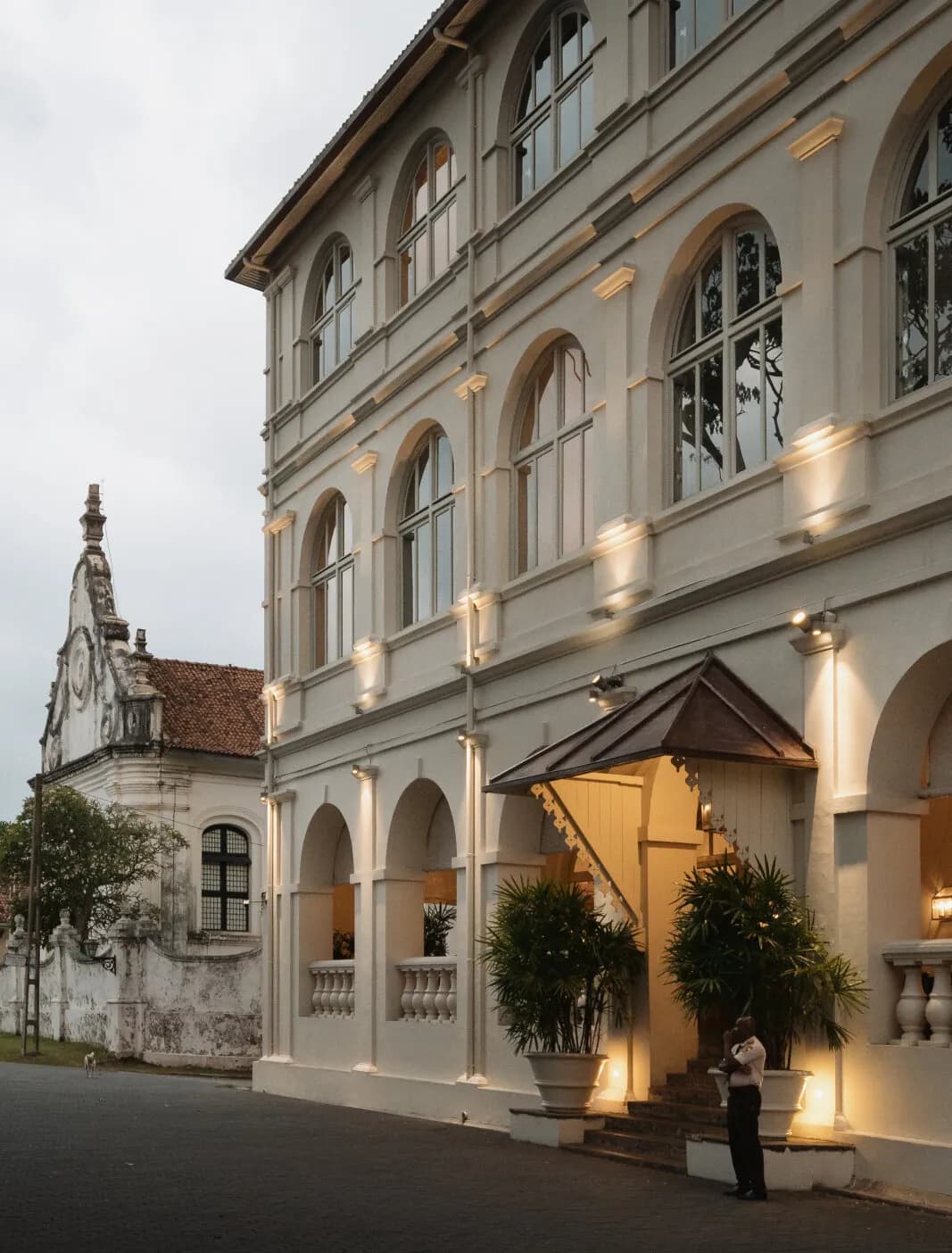 Amangalla colonial facade lit at dusk with illuminated arches on Church Street, Galle Fort